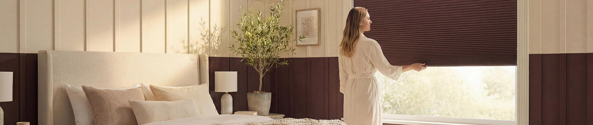 Image of a woman closing blinds in a bedroom