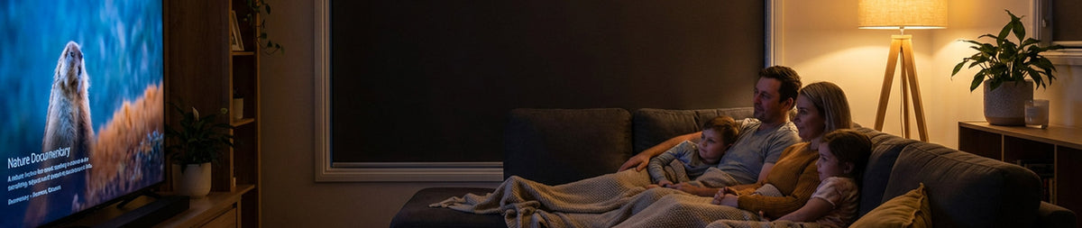 Image of a family watching TV in a dark media room with blackout blinds